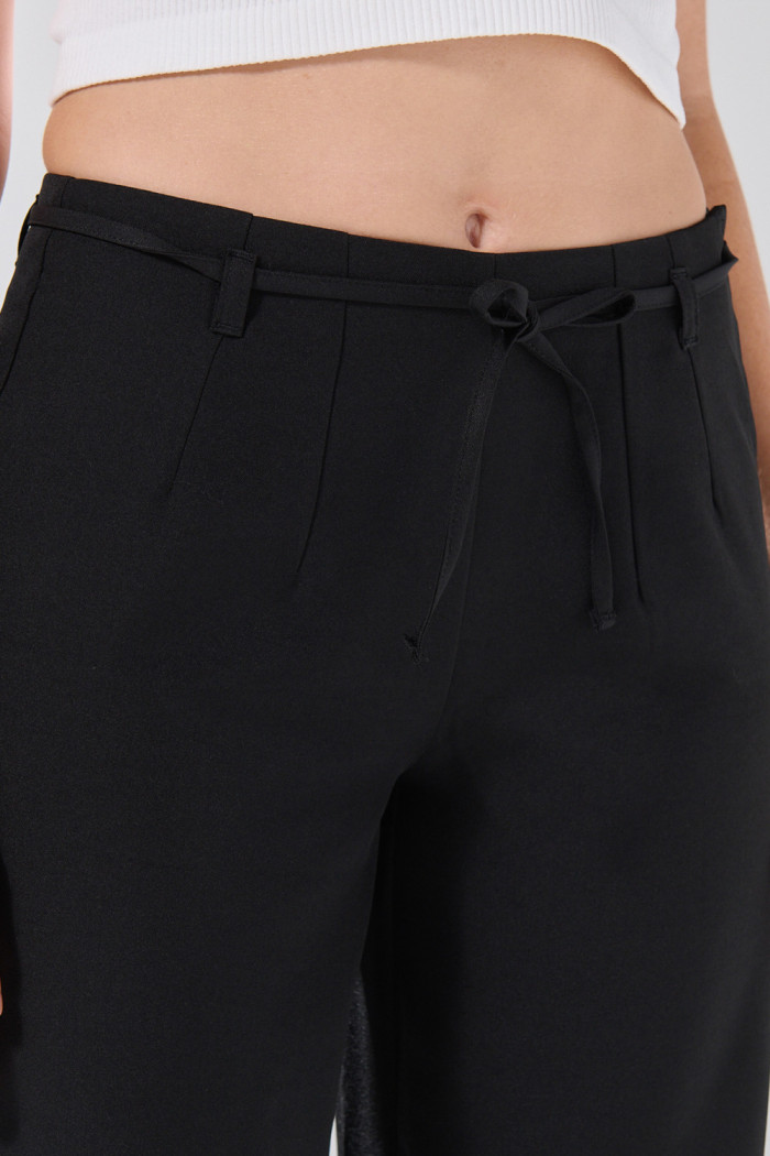 Pantalón negro palazzo con cinturón y bota ancha
