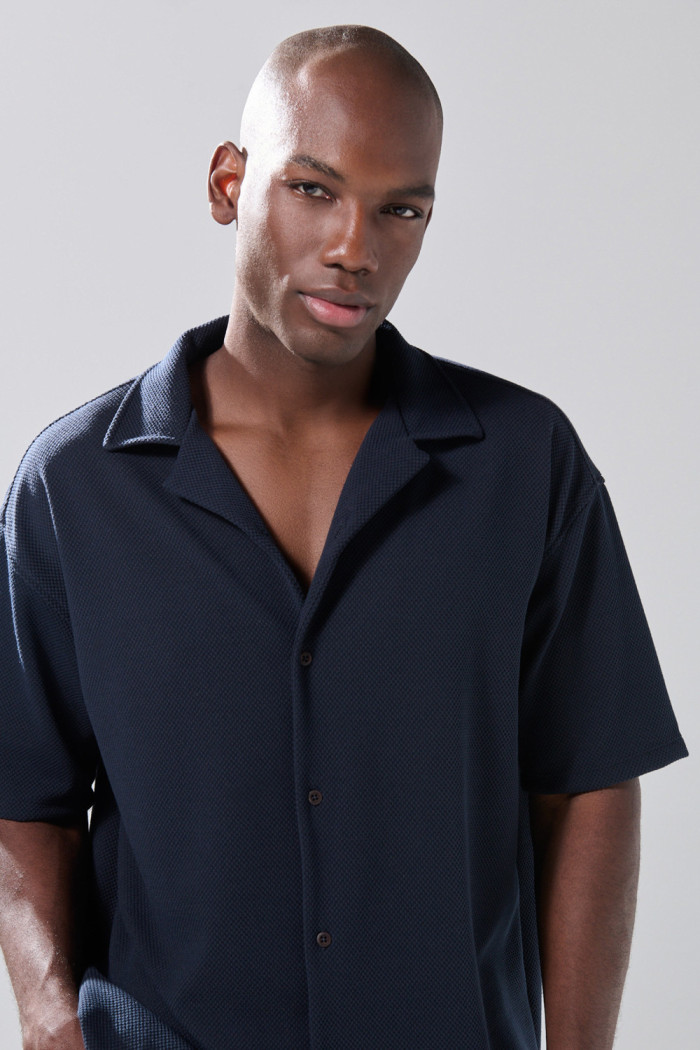 Camisa cuello resort azul oscura con texturas sutiles
