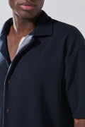 Camisa cuello resort azul oscura con texturas sutiles
