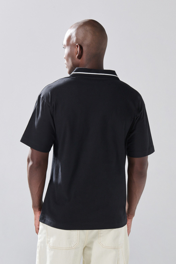 Camiseta polo negra con arte college y abertura V
