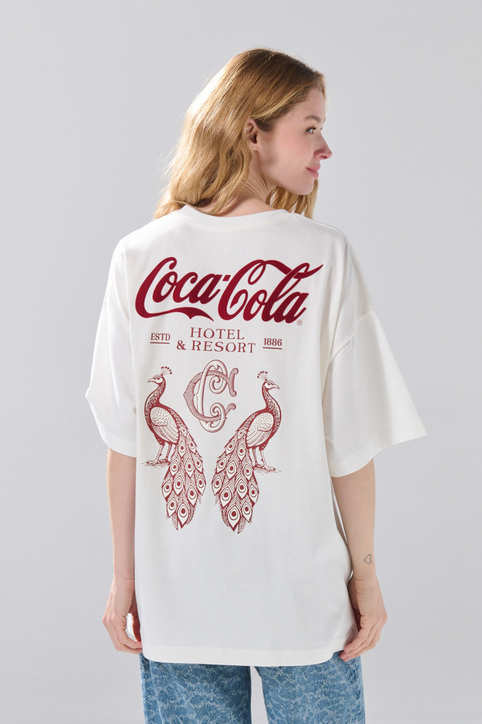 Camiseta oversize manga corta crema con arte de Coca-Cola
