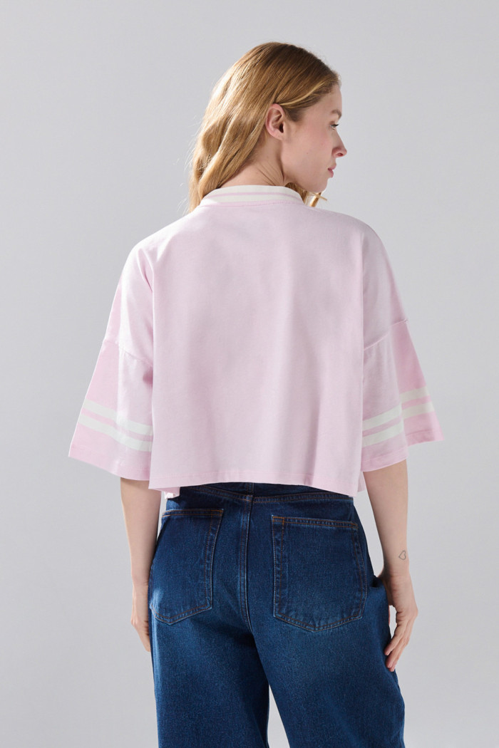 Camiseta crop top rosada oversize college con cuello V

