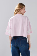 Camiseta crop top rosada oversize college con cuello V
