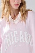 Camiseta crop top rosada oversize college con cuello V
