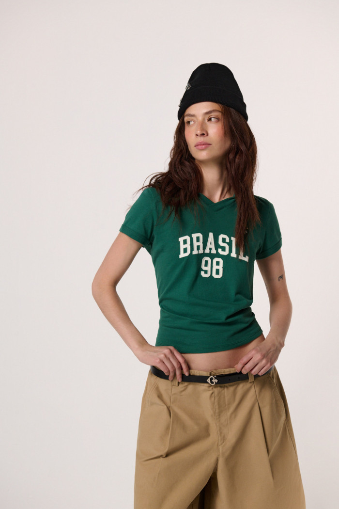 Camiseta cuello polo verde con arte college de Fan Edition
