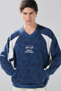 Buzo cuello V oversize azul con arte college de Fan Edition
