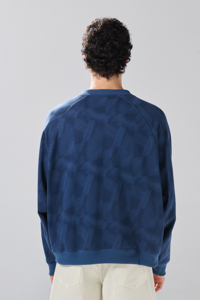 Buzo cuello V oversize azul con arte college de Fan Edition
