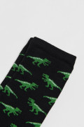 Medias negras largas con diseños de dinosaurios verdes
