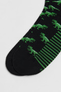 Medias negras largas con diseños de dinosaurios verdes
