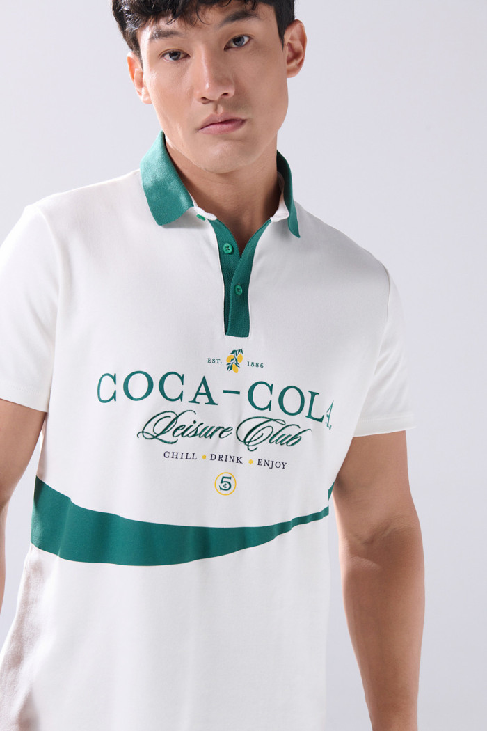 Camiseta polo crema clara con diseños de Coca-Cola
