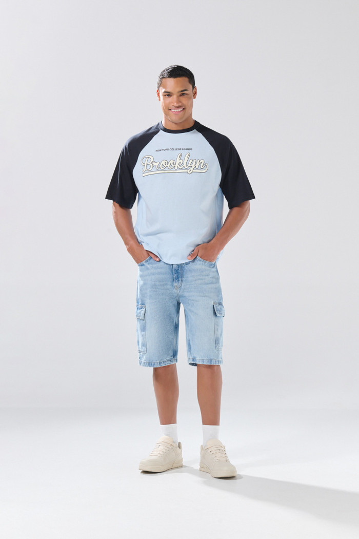 Camiseta azul clara manga ranglan con texto college
