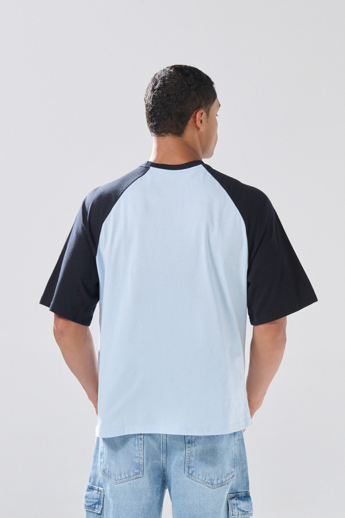 Camiseta azul clara manga ranglan con texto college
