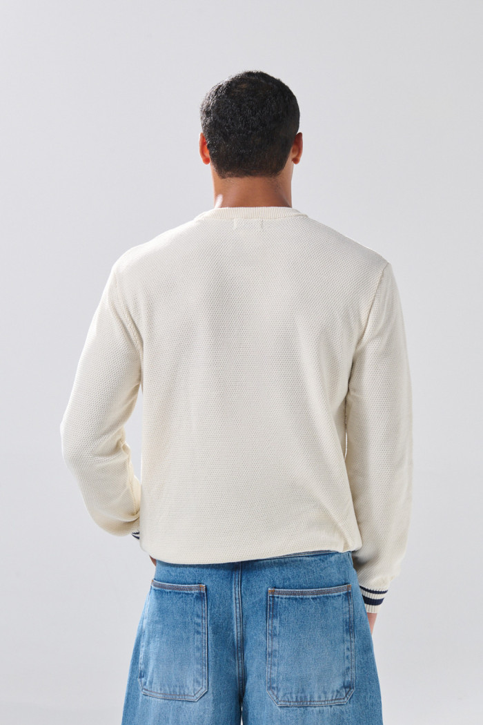 Suéter cuello redondo crema claro con diseño college
