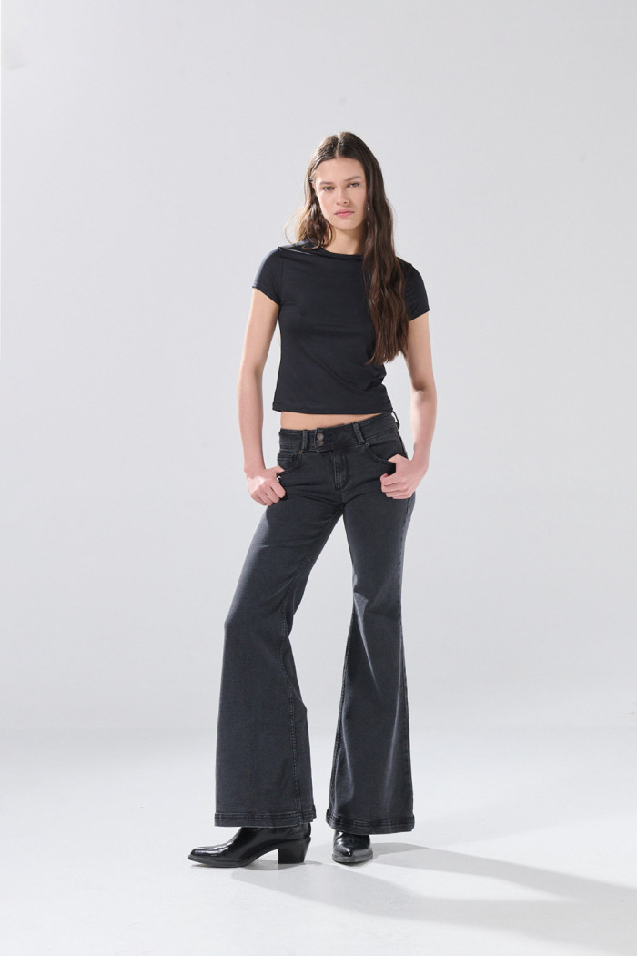Jean flare gris intenso con bota amplia y tiro bajo