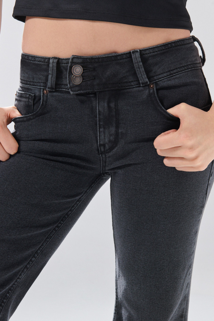 Jean flare gris intenso con bota amplia y tiro bajo