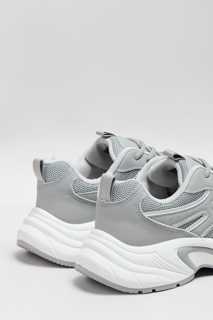 Tenis de plataforma grises con suelas altas blancas
