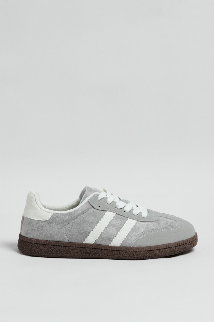 Tenis casuales unicolores con diseños blancos localizados
