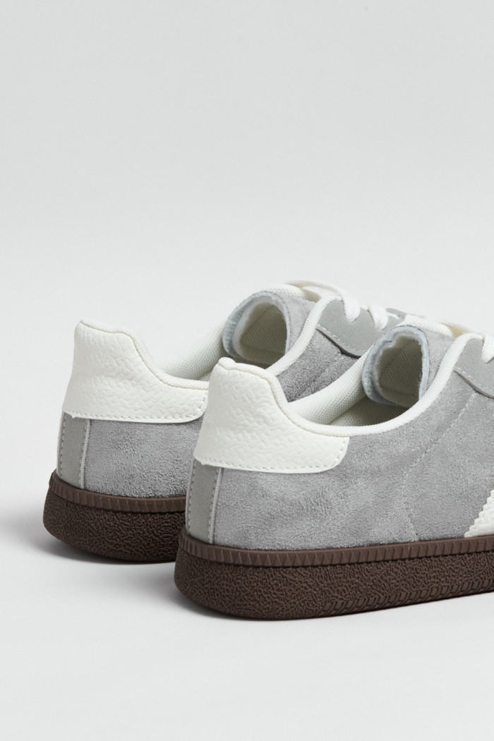 Tenis casuales unicolores con diseños blancos localizados
