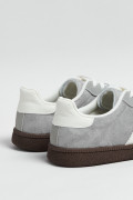 Tenis casuales unicolores con diseños blancos localizados
