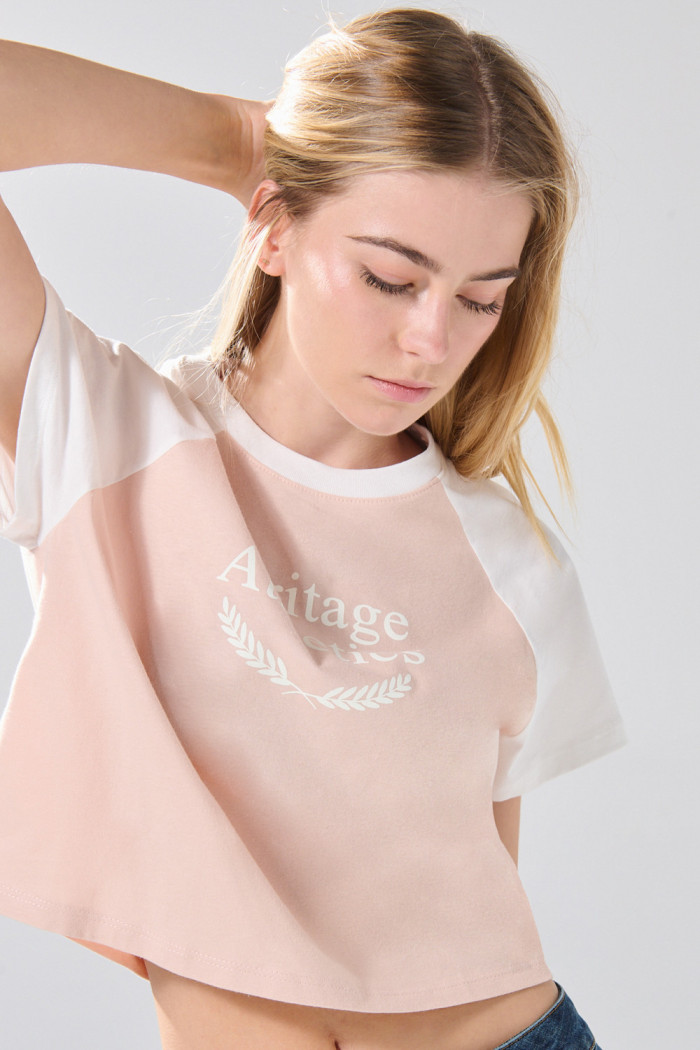 Camiseta crop top rosada college con manga ranglan
