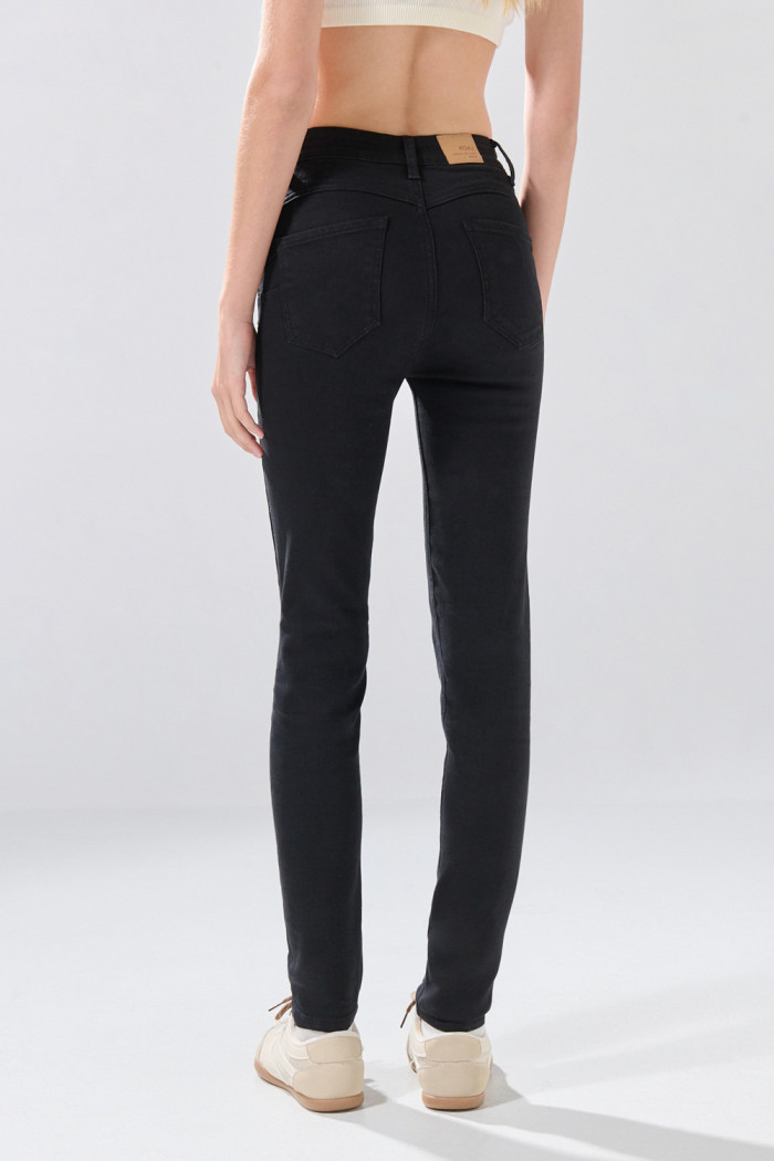 Jean push up tiro alto negro con realce y botón
