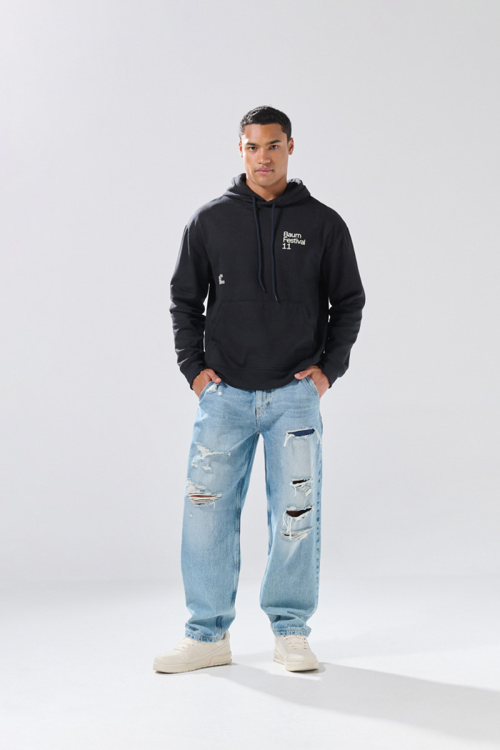 Buzo oversize negro con capota y diseños de Baum Festival
