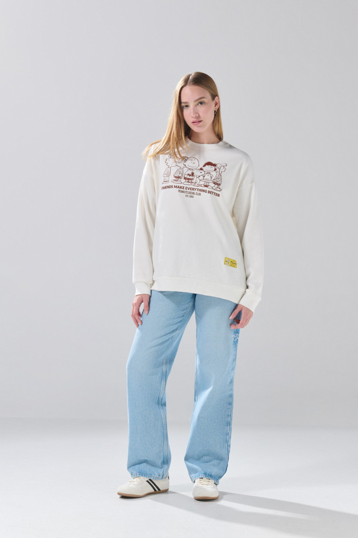 Buzo oversize cuello redondo crema con arte de Snoopy

