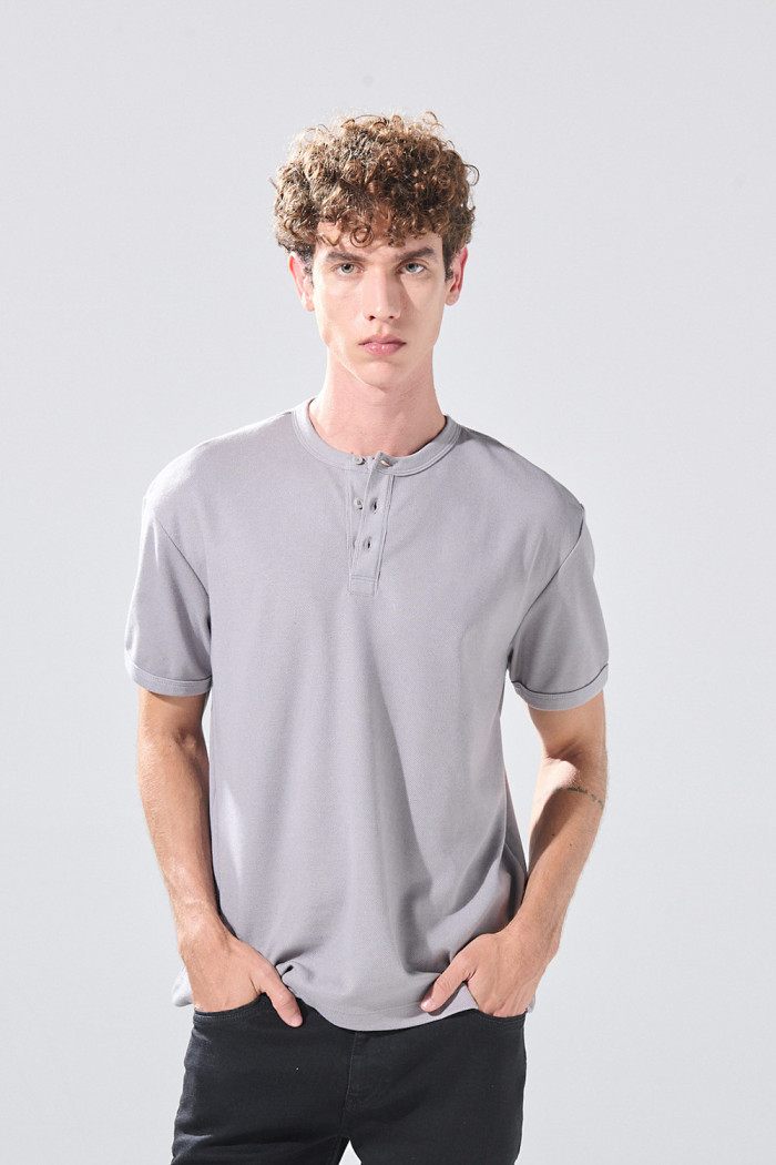 Camiseta cuello redondo unicolor con botones visibles
