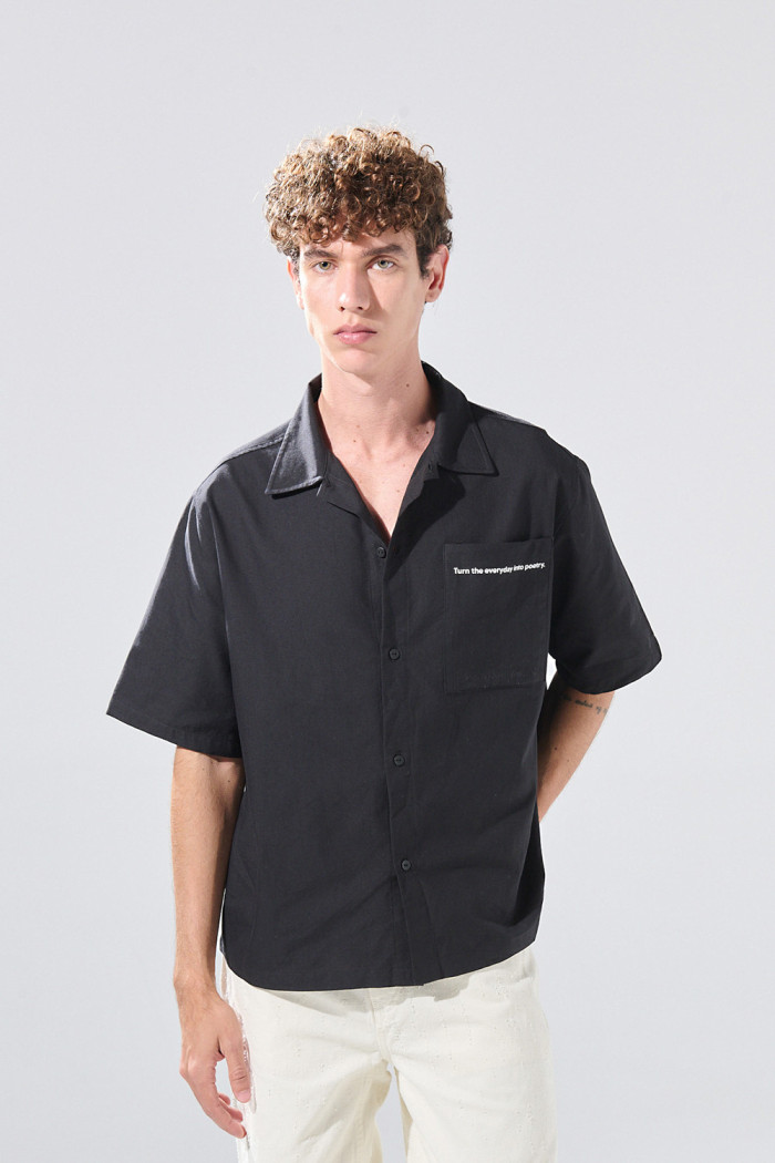 Camisa negra con cuello resort, botones y texto de Poetry
