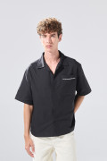 Camisa negra con cuello resort, botones y texto de Poetry
