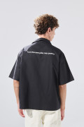 Camisa negra con cuello resort, botones y texto de Poetry
