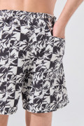 Bermuda playera kaki con diseños de cuadros y palmeras
