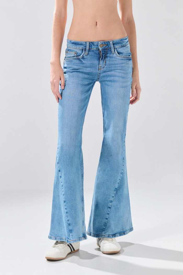 Jean flare azul claro con tiro medio, desgastes y bota ancha
