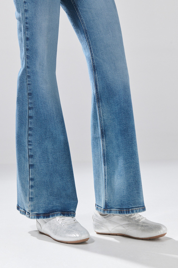 Jean azul medio flare con bota ancha y ligeros desgastes
