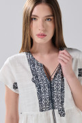 Blusa crema clara estampada con escote V y manga corta