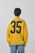 Buzo oversize cuello redondo amarillo con artes college
