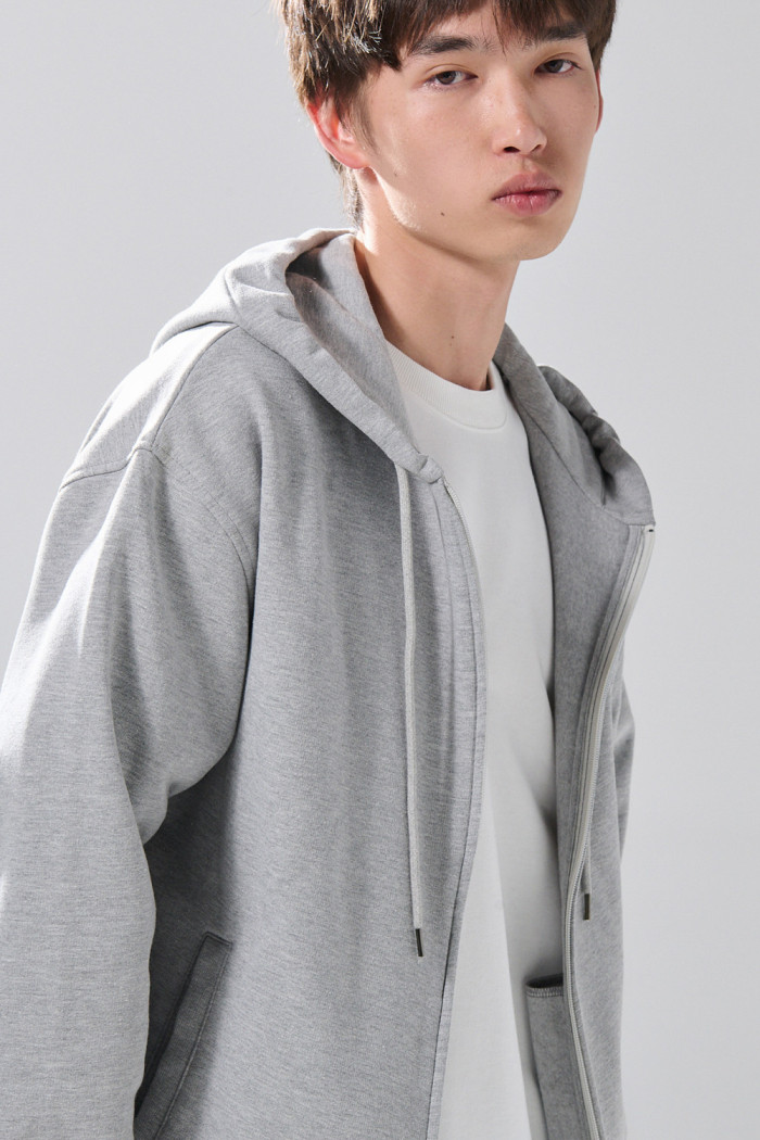 Buzo gris medio oversize con capota y cremallera
