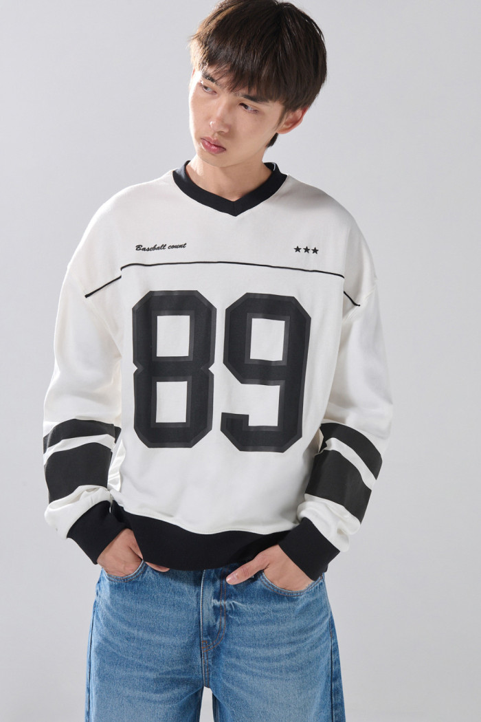 Buzo crema claro oversize con arte college y cuello V
