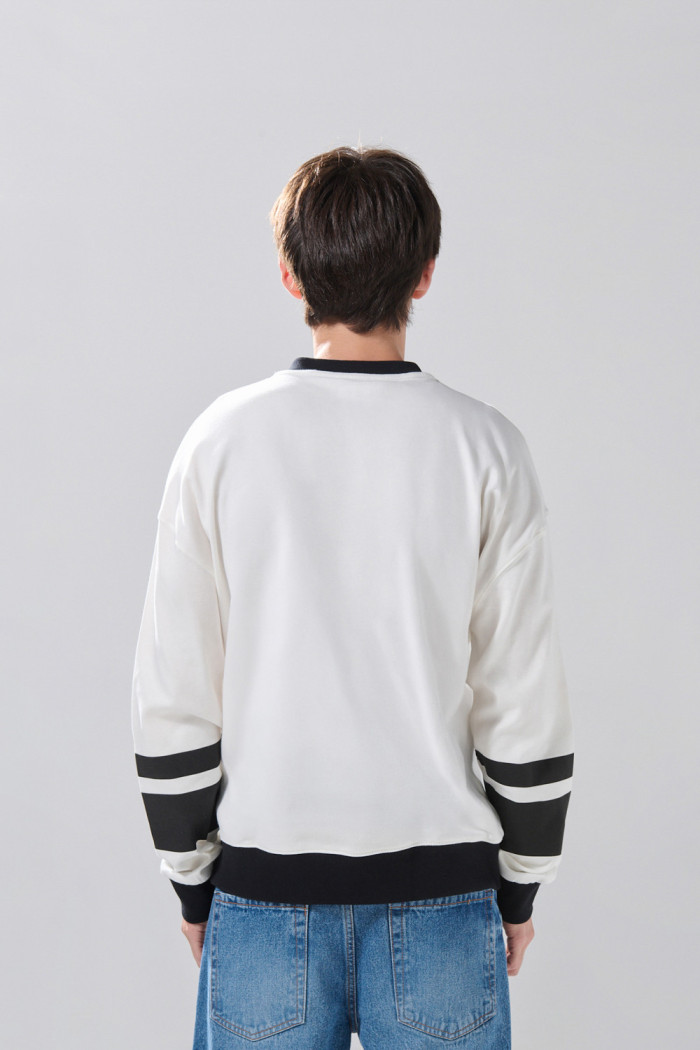 Buzo crema claro oversize con arte college y cuello V
