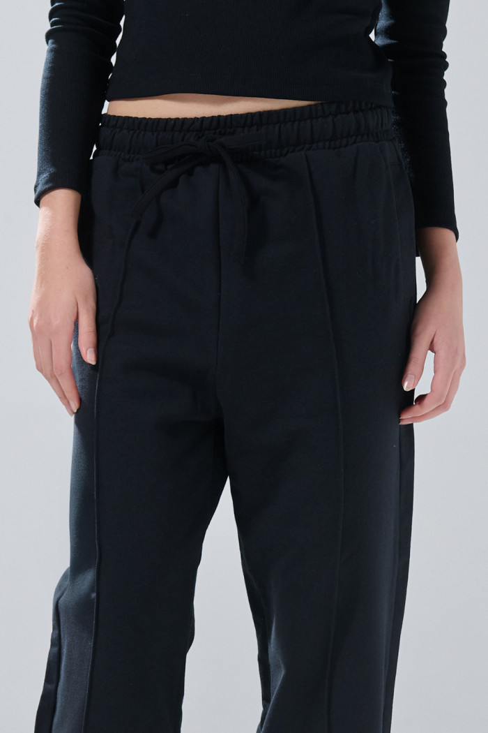 Pantalón jogger unicolor con bota ancha y vena en frente
