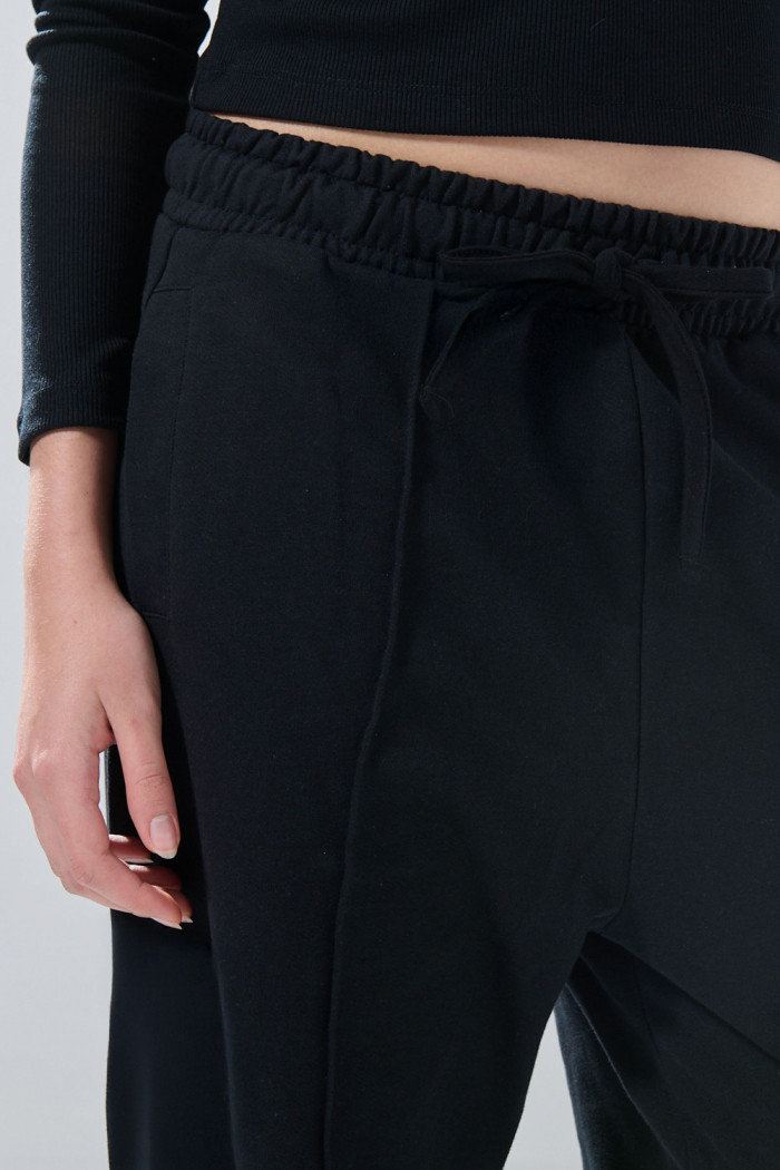 Pantalón jogger unicolor con bota ancha y vena en frente

