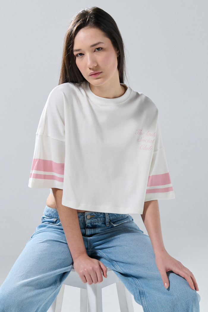 Camiseta crema crop top con arte college y manga corta
