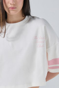 Camiseta crema crop top con arte college y manga corta
