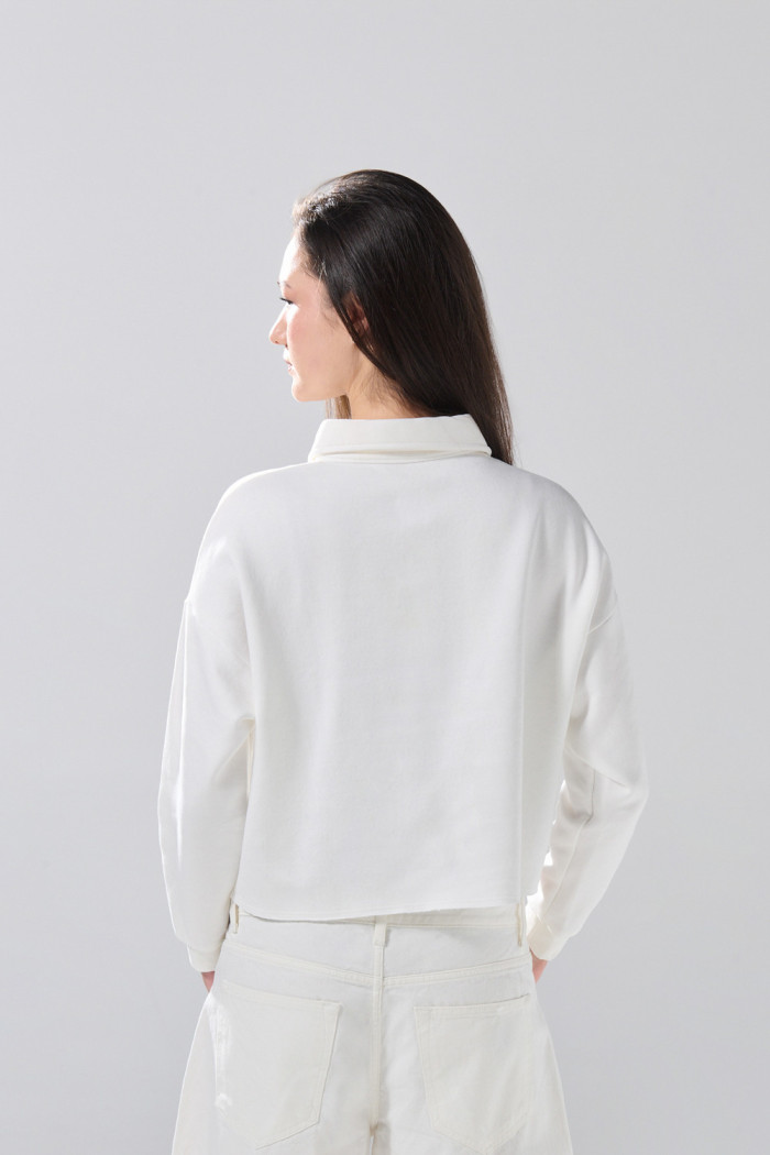 Buzo cuello sport crema con diseño college y cremallera
