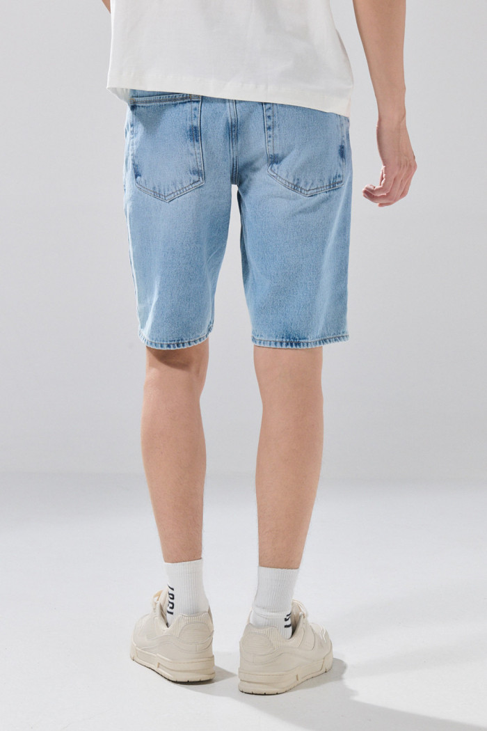 Bermuda slim infaltables de jean azul clara con desgastes

