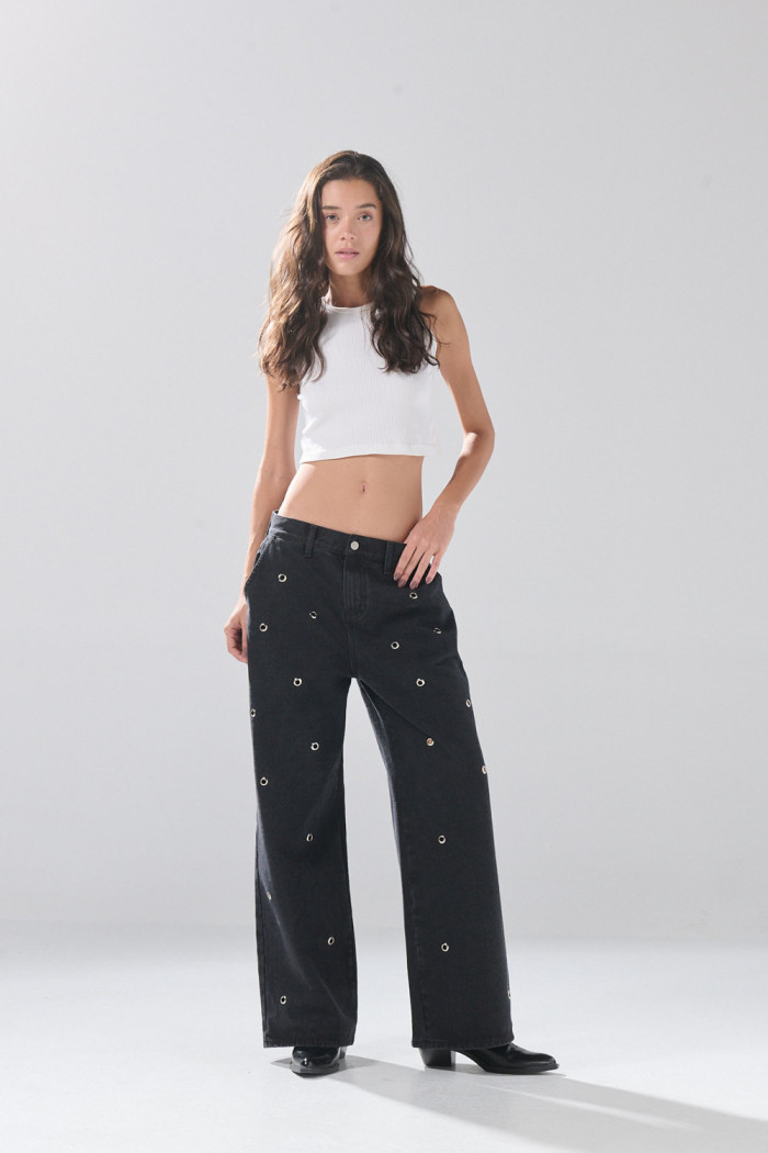 Jean skater gris intenso con ojaletes metálicos y bota ancha

