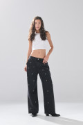 Jean skater gris intenso con ojaletes metálicos y bota ancha
