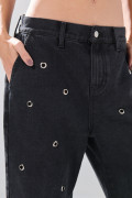 Jean skater gris intenso con ojaletes metálicos y bota ancha
