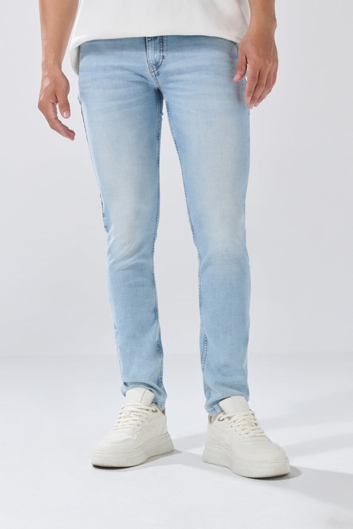 Jean skinny tiro bajo azul con desgastes y cremallera

