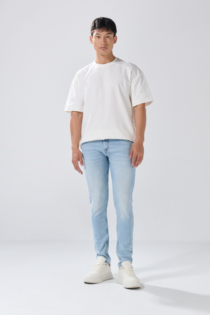 Jean skinny tiro bajo azul con desgastes y cremallera
